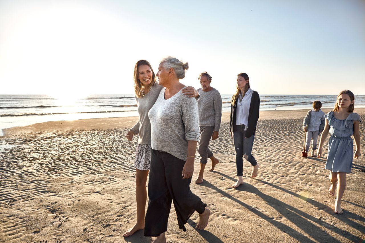 Familie går tur på en strand